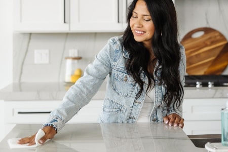 A woman wipes her counter-tops trying the cleaning tips from Zerorez.
