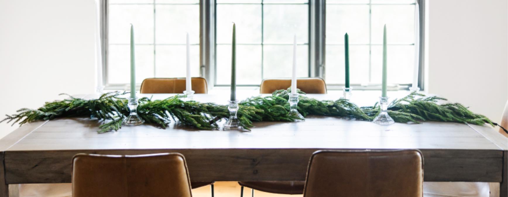 Greenery and candles on a beautiful, clean wood table thanks to Zerorez.