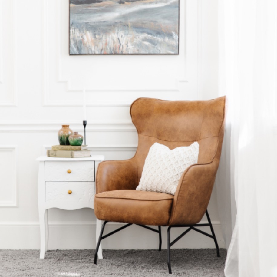 Clean, orange leather chair with small dresser with Zerorez.