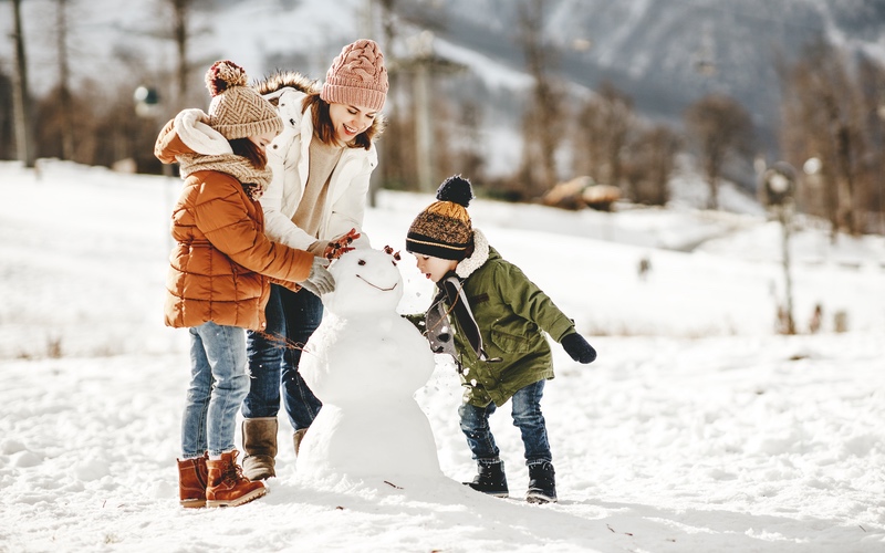 A family building a snowman - Enjoy your favorite outdoor activities this winter while keeping your carpets clean with Zerorez